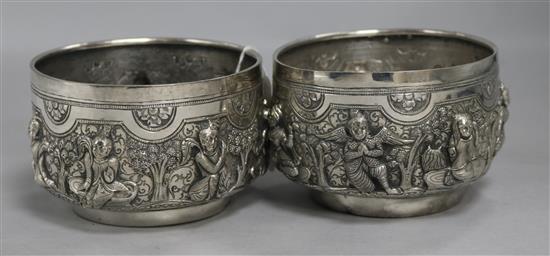 Two Burmese white metal Thabeik bowls of traditional form, embossed with deities and figures,